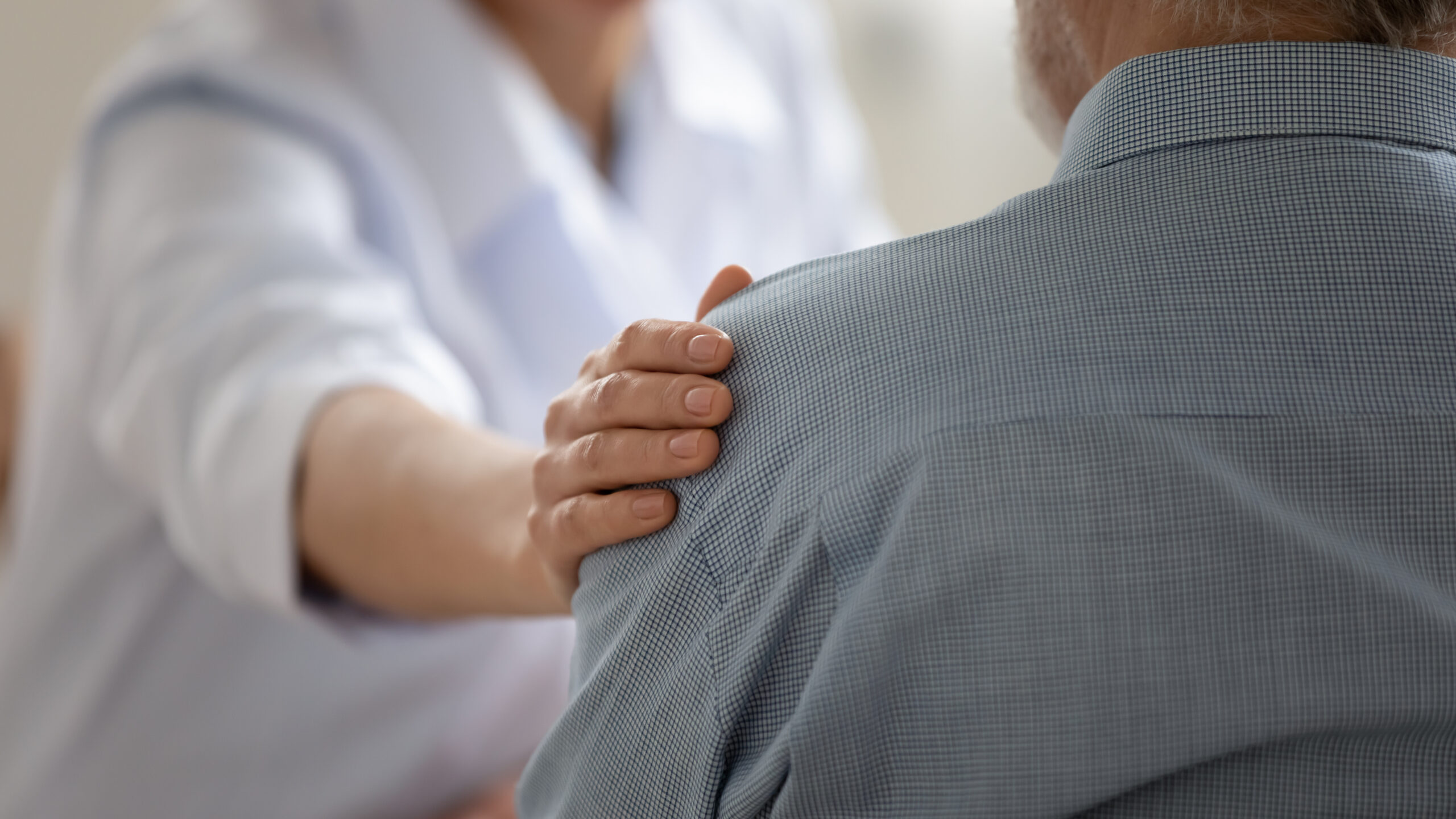Doctor with their hand on a patient's shoulder